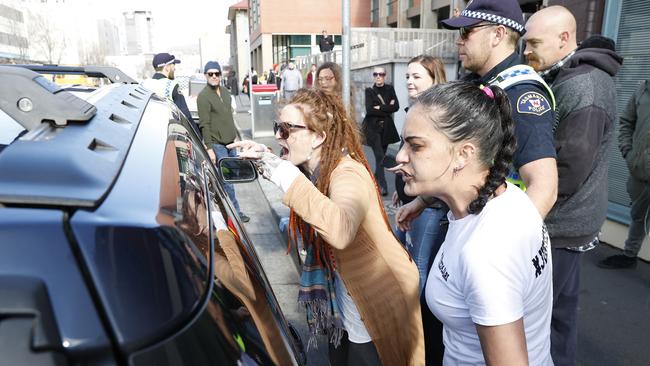 The mother of Jari Wise, Faith Tkalac (red dreadlocks) alongside family and friends yell and at and chase down Jari's former girlfriend, Melissa Oates as she leaves Hobart Magistrates Court under police escort after her court hearing was adjourned. Picture: Zak Simmonds