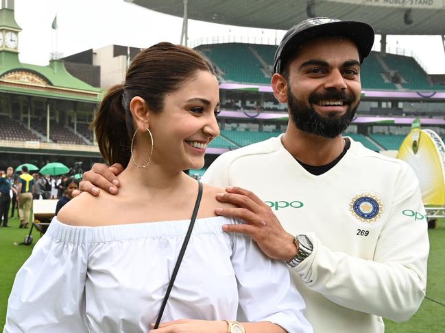 (FILES) In this file photo taken on January 7, 2019, India's captain Virat Kolhi and his wife Anushka Sharma walk on the field as they celebrate India's series win on the fifth day of the fourth and final cricket Test against Australia at the Sydney Cricket Ground in Sydney. - Indian cricketing star Kohli on August 27 announced that he and his Bollywood actress wife Anushka are expecting their first child in January next year. (Photo by Peter PARKS / AFP) / -- IMAGE RESTRICTED TO EDITORIAL USE - STRICTLY NO COMMERCIAL USE --