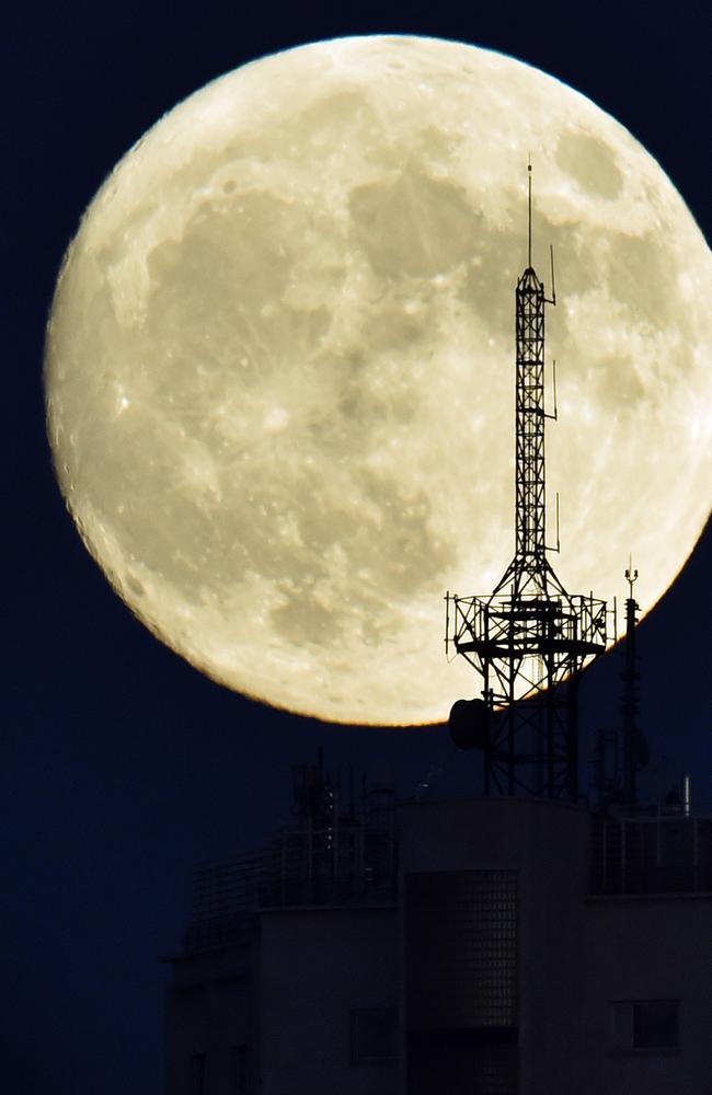 The moon rises over an antenna on the top of a building in Madrid on November 13, 2016, on the eve of a “supermoon”. On November 14, 2016, the moon will orbit closer to the earth than at any time since 1948, named a ‘supermoon’, it is defined by a Full or New moon coinciding with the moon’s closest approach to the Earth. Picture: AFP PHOTO / GERARD JULIEN