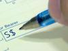 Generic photo of a person writing a cheque. Picture: iStock