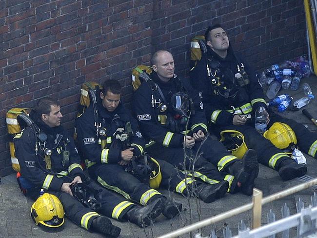 Firefighters rest after battling the London inferno. Picture: AP
