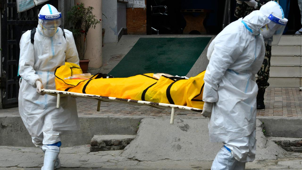 Nepal army personnel carry the body of a person who died from COVID-19 before taking it to a crematorium in Kathmandu on May 5, 2021. (Photo by PRAKASH MATHEMA / AFP)