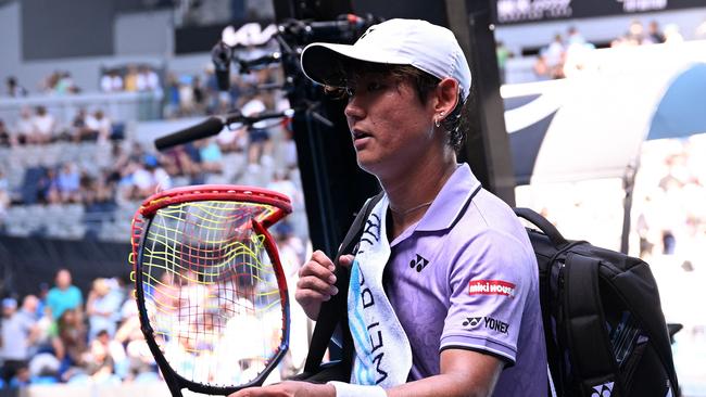 Japan's Yoshihito Nishioka prepares to hand his smashed racket to a fan.