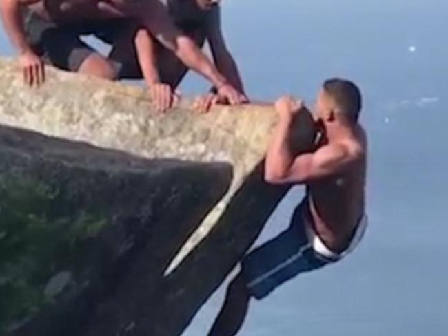 ONE TIME WEB USE ONLY - FEE APPLIES FOR REUSE - Daredevil pictured hanging off the side of a cliff is helped back to safety in Pedra da Gávea, Rio De Janeiro. Picture: Caters News