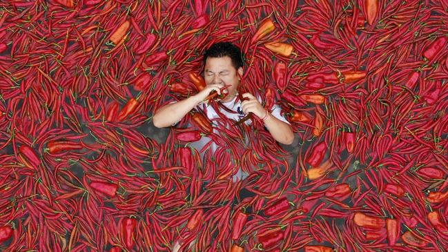 NINGXIANG, CHINA - JULY 08: A challengers lays in a chili-covered pool eat chilies during a chili-eating contest on July 8, 2018 in Ningxiang, Hunan Province of China. Citizen Tang Shuaihui ate 50 chilies in one minute and won the contest. (Photo by Visual China Group via Getty Images)