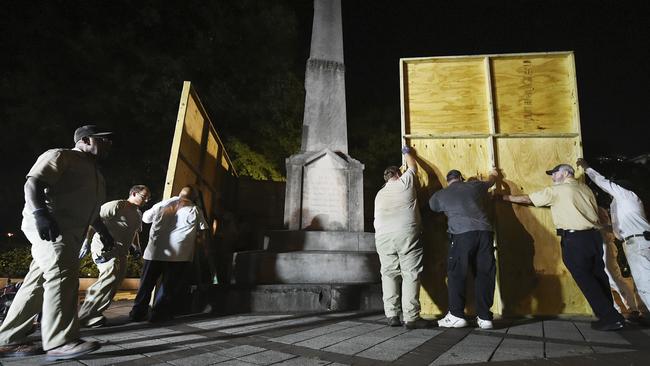 Birmingham city workers use plywood panels to cover the Confederate Monument in Linn Park, in Birmingham, Ala., Tuesday night, Aug. 15, 2017, on orders from Mayor William Bell. (Joe Songer  /AL.com via AP)