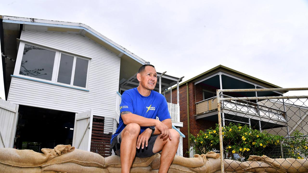 Shayne Kong looks out to the sea while being as prepared as he can with sandbags at his home in Wynnum. Picture: John Gass