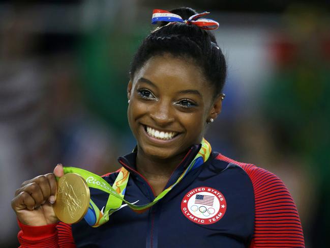 FILE - In this Aug. 16, 2016 file photo, United States gymnast Simone Biles displays her gold medal for floor during the artistic gymnastics women's apparatus final at the 2016 Summer Olympics in Rio de Janeiro, Brazil. In a statement via Twitter on Monday, Jan. 15, 2017, Biles says she is among the athletes sexually abused by a now-imprisoned former USA Gymnastics team doctor.. (AP Photo/Rebecca Blackwell, File)