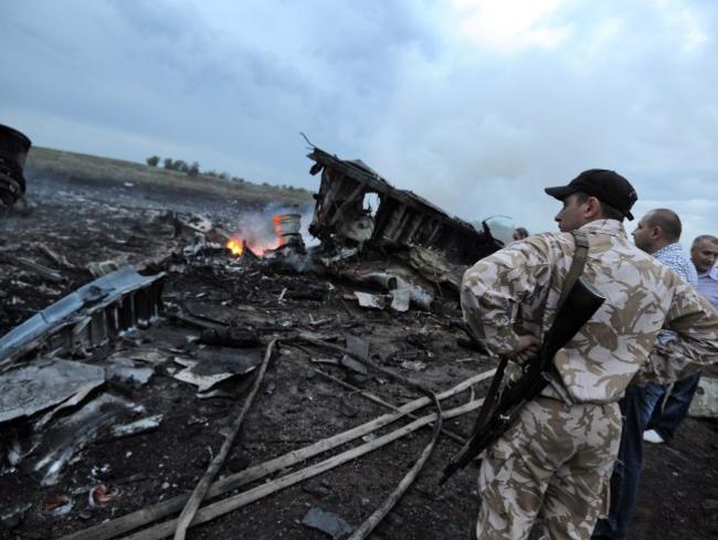 People stand next to the wreckages of the Malaysian airliner carrying 295 people from Amsterdam to Kuala Lumpur after it crashed, near the town of Shaktarsk, in rebel-held east Ukraine. Picture: AFP Photo/Dominique Faget