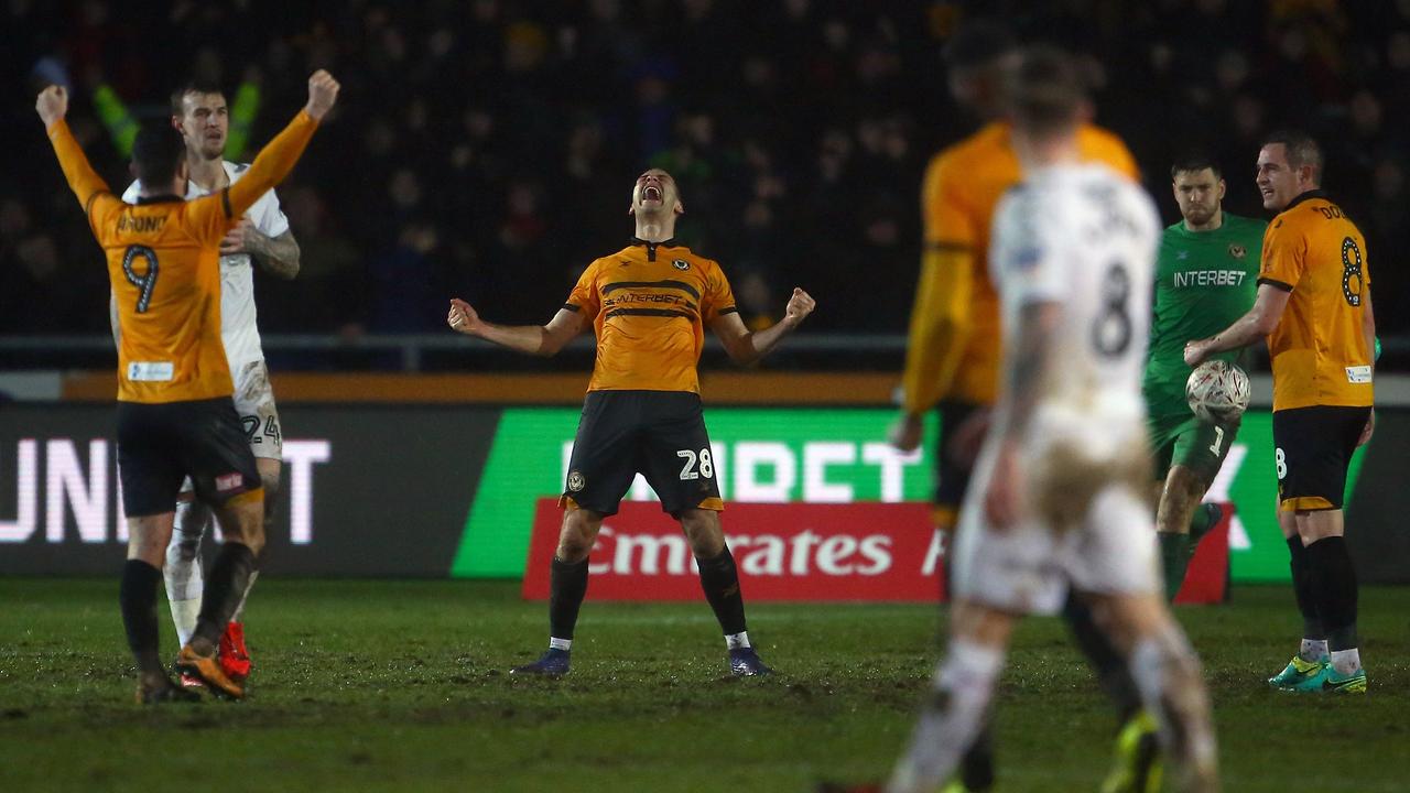 Newport County's Irish striker Padraig Amond (L) and defender Mickey Demetriou (C) celebrate at the final whistle 