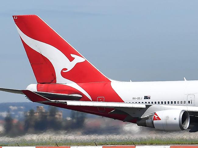 A Qantas Airways plane takes off at Sydney Airport in Sydney on March 19, 2020. - Australia's biggest airline Qantas said it would halt all international flights and suspend 20,000 staff in response to the coronavirus pandemic, days after the island nation's other main carrier Virgin shut its overseas routes. (Photo by Saeed KHAN / AFP)