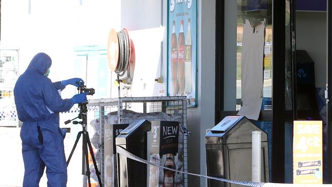 A forensic officer at the window where the message was scrawled. Picture: Kym Smith