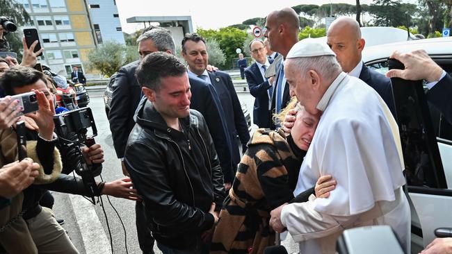 Pope Francis hugs Serena Subania as her husband Matteo Rugghia (L) reacts, a couple who lost their five-year-old child a day earlier, as the Pope leaves the Gemelli hospital. Picture: AFP