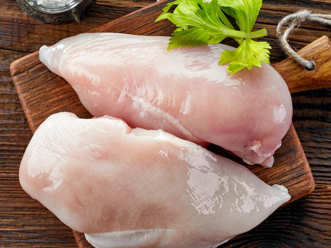 raw chicken fillets on wooden cutting board, top view