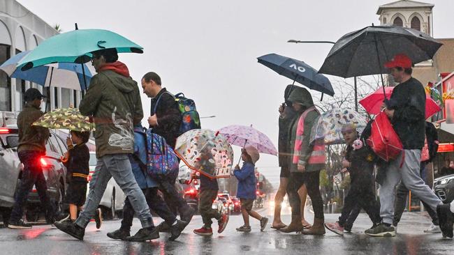 Pedestrians cross Goodwood Rd at Goodwood in the rain on Thursday morning. Picture: NCA NewsWire/Brenton Edwards