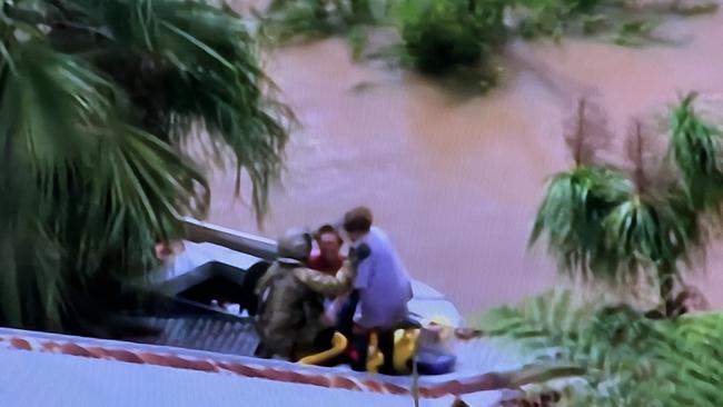 Sky TV frame grabs of a live rescue from the top of a home in Lismore by the defence force - a woman was airlifted to a helicopter