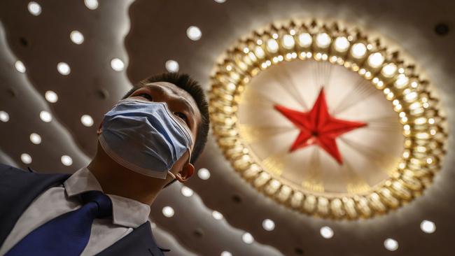 A Chinese security officer wears a protective mask at the end of the closing session of the National People's Congress at the Great Hall of the People. Picture: Getty Images