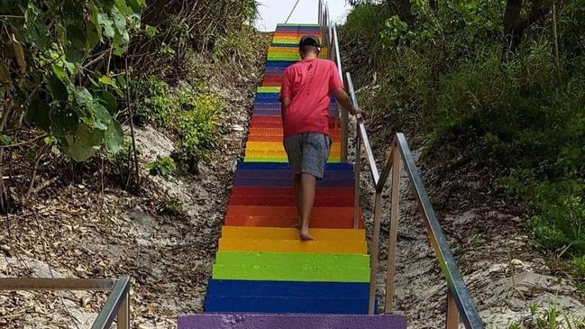 The painted stairs became an iconic symbol for tourism in Rainbow Beach. Pictured is Jack Saunders.