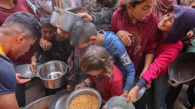 Palestinians shove to get a ration of hot food from a charity kitchen set up at the Islamic University campus in Gaza City. Picture: AFP