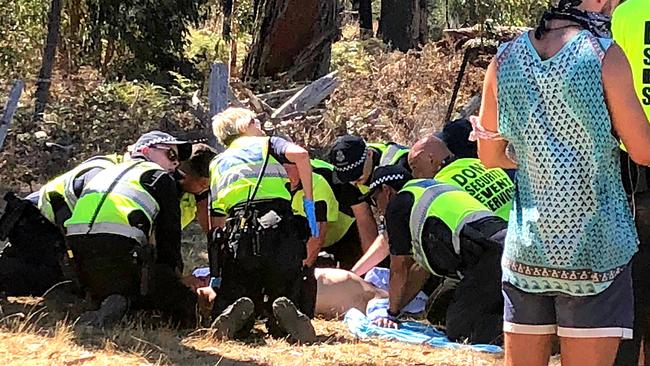 Emergency services attend to a man before he is loaded into an ambulance at the Rainbow Serpent Festival in January. 