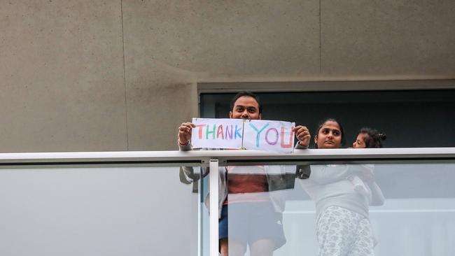 Thankful COVID-19 quarantined travellers watch Hans performing in Hindmarsh Square. Picture: Russell Millard