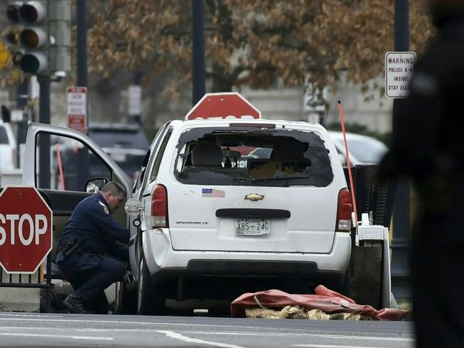 An agent inspects the car sitting after the incident. Picture: AFP/Saul Loeb