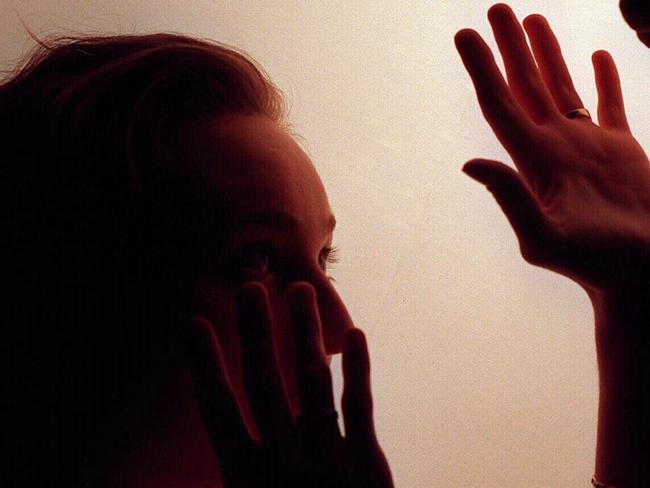 Domestic violence silhouette generic image - fist raised against woman./Violence