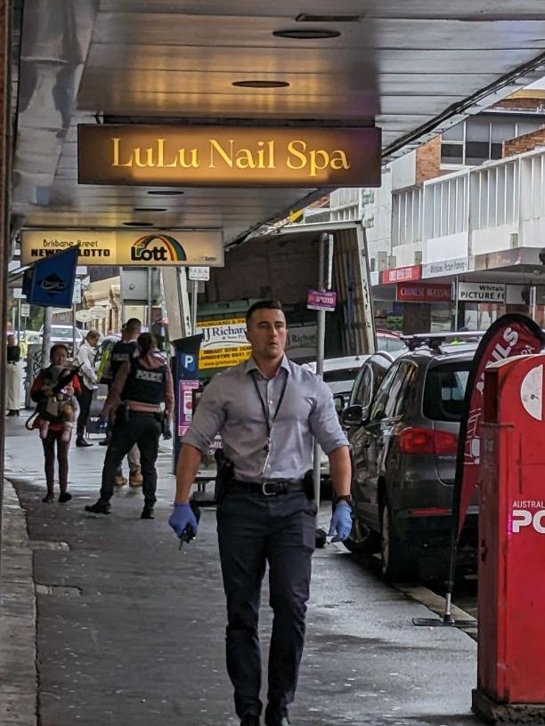 A police officer wearing gloves walking near the scene of the incident on Brisbane St, Launceston. Picture: Alex Treacy