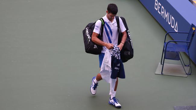 Novak Djokovic walks off the court after being defaulted due to inadvertently striking a lineswoman with a ball hit in frustration at the US Open. Picture: Getty Images