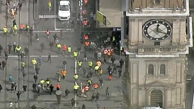 Protesters walking through traffic in Melbourne’s CBD.