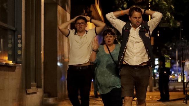 People with their hands on their heads about 10 minutes after midnight as they leave from inside a police cordon after an attack in London. Armed British police rushed to London Bridge late Saturday after reports of a vehicle running down pedestrians and people being stabbed nearby. Picture: AP
