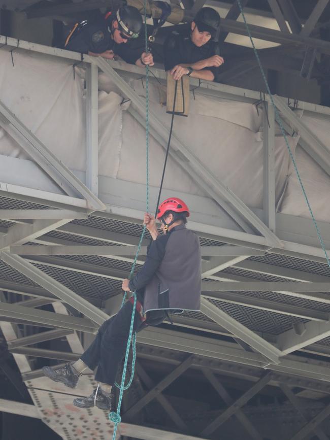 An Extinction Rebellion protester lowers himself from the Story Bridge. Picture: Peter Wallis