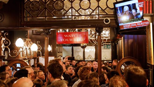 Drinkers watch a television screen in the Red Lion public house on Whitehall, as it shows Britain's Prime Minister Theresa May speaking in parliament on D-Day. Picture: AFP 