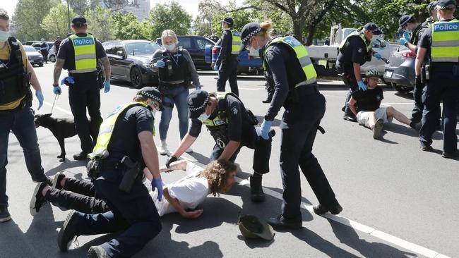 Police tackle a protester to the ground. Picture: David Crosling