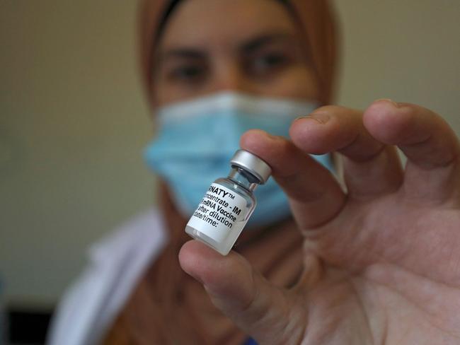 A Palestinian healthcare worker displays a vial of COVID-19 vaccine, at the start of the inoculation campaign, at a hospital in the West Bank city of Ramallah on March 21, 2021. - Thousands of Palestinian health workers, the elderly, and patients with cancer or kidney disease were set to get Covid-19 vaccines as the health ministry ramped up its inoculation campaign. The rollout came days after some 60,000 doses of Pfizer/BioNTech and AstraZeneca doses arrived in the Israeli-occupied West Bank via the Covax scheme of the World Health Organisation. (Photo by ABBAS MOMANI / AFP)