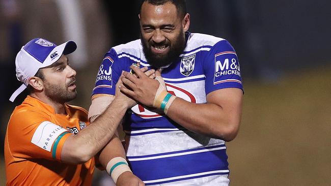 Sam Kasiano clutches at his sternum as he is taken off.