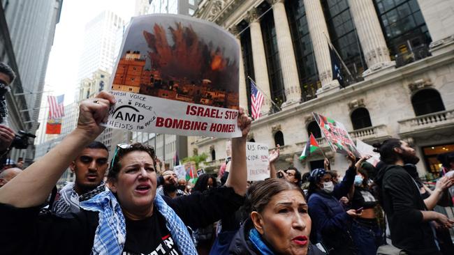 Protesters hold signs during the "Flood Wall Street for Gaza" rally outside the New York Stock Exchange. National security agencies believe Australians could be caught up in attacks around the world in response to the ongoing war.