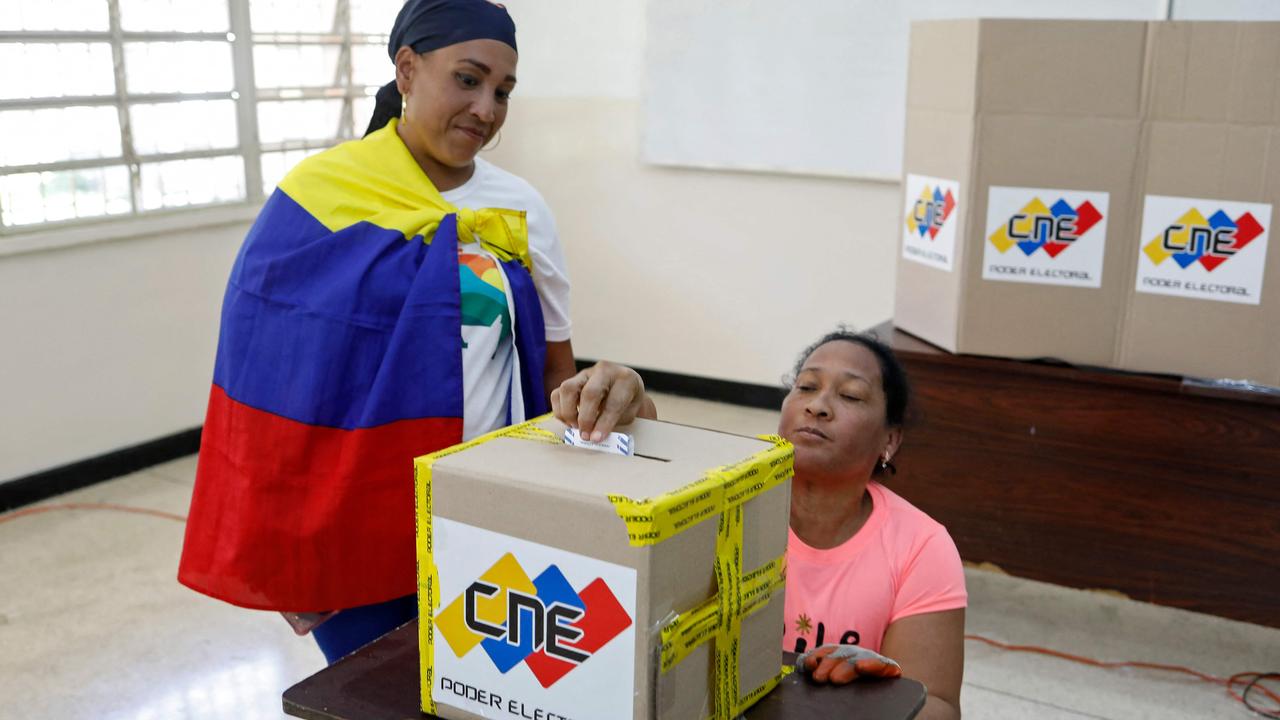 A woman votes at a polling station during the consultative referendum on Venezuelan sovereignty over the Essequibo region. (Photo by Pedro RANCES MATTEY / AFP)