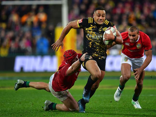 Wellington Hurricanes' Ngani Laumape (C) is tackled by British and Irish Lions players James Haskell (L) and Jonathan Joseph during their rugby union match at Westpac Stadium in Wellington on June 27, 2017.  / AFP PHOTO / Marty MELVILLE