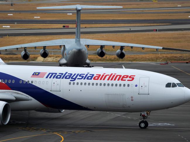 PERTH, AUSTRALIA - MARCH 25: A Malaysia Airlines plane prepares to go out onto the runway and passes by a stationary Chinese Ilyushin 76 aircraft (top) at Perth International Airport on March 25, 2014 in Perth Australia. The Australian Maritime Safety Authority has suspended the air and sea search for the missing Malaysian Airlines flight MH370 due to poor weather conditions in the search area. Search operations are expected to resume tomorrow. (Photo by Greg Wood - Pool/Getty Images)