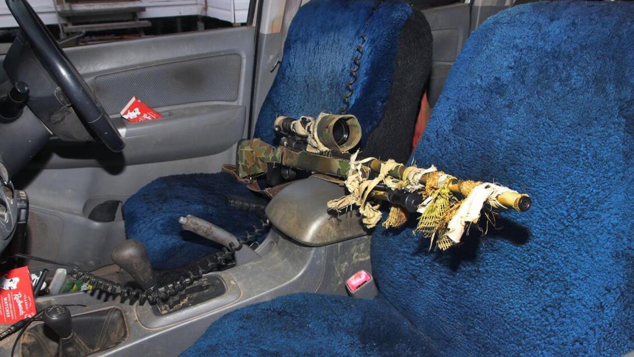 A rifle covered in camouflage inside a car at the front entrance of the Train house.