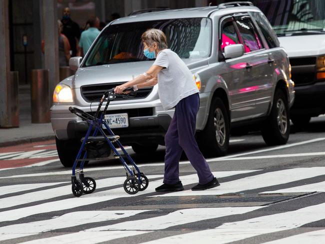 A woman wears a face mask as she crosses the street in Midtown Manhattan. Picture: AFP.