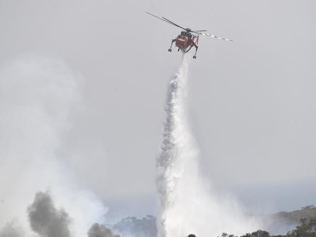 A helicopter dropping water on bushfires sweeping through Stokes Bay on Kangaroo Island, southwest of Adelaide. Picture: David Mariuz