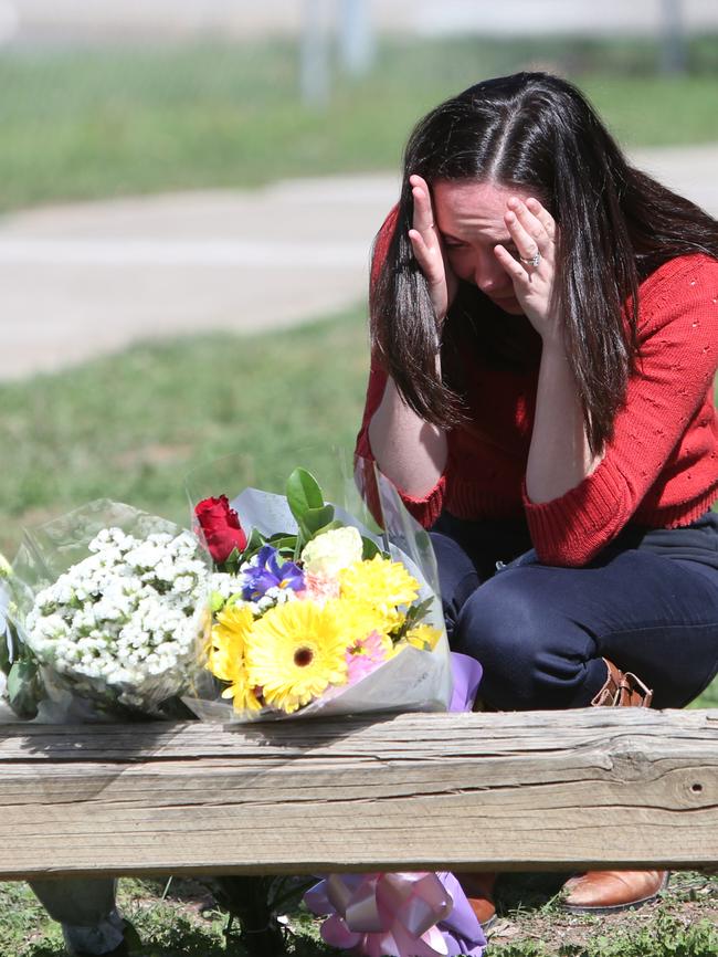 A woman leaves flowers at the scene of the alleged attack. Picture: Kym Smith