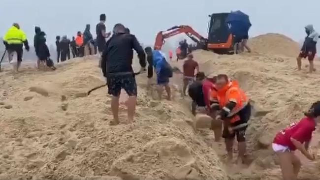 Mr Weber helps hundreds of people unblock The Entrance Channel during torrential rain last weekend. Picture: Facebook