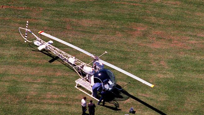 Police inspecting abandoned White Bell 47G helicopter in Ryde's Christie Park which was hijacked by Lucy Dudko who forced pilot Tim Joyce to land inside Silverwater Metropolitan Reception &amp; Remand Centre to help her boyfriend &amp; armed robber John Killick to escape from the prison.