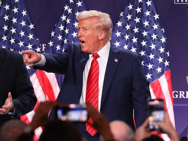 DORAL, FLORIDA - JANUARY 27: U.S. President Donald Trump acknowledges the crowd as House Majority Whip Tom Emmer (R-MN) (L) and House Speaker Mike Johnson (R-LA) applaud after Trump addressed the 2025 Republican Issues Conference at the Trump National Doral Miami on January 27, 2025 in Doral, Florida. The three-day planning session was expected to lay out Trump's ambitious legislative agenda.   Joe Raedle/Getty Images/AFP (Photo by JOE RAEDLE / GETTY IMAGES NORTH AMERICA / Getty Images via AFP)