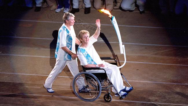 Torchbearer Betty Cuthbert is pushed by Raelene Boyle during the Opening Ceremony of the Sydney 2000 Olympic Games at the Olympic Stadium in Homebush.