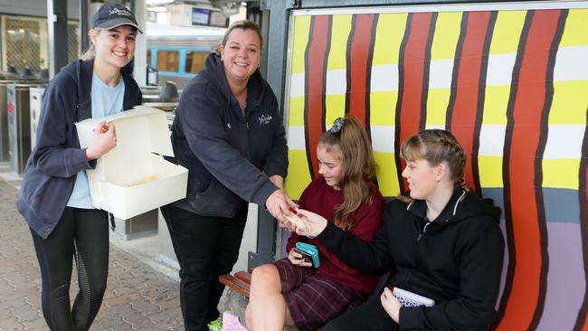 Kirsty Hutchinson and Danielle Long pass out sausage rolls at Campbelltown Station. Pictures: Ian Svegovic