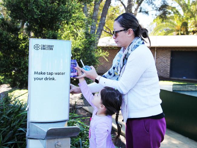 Bincy Low and daughter Sophie filling their bottles at the new water refill station at Gough Whitlam Park, Earlwood.